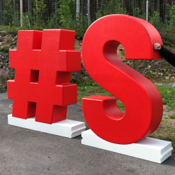 Jalustalla seisovat 3D kirjaimet